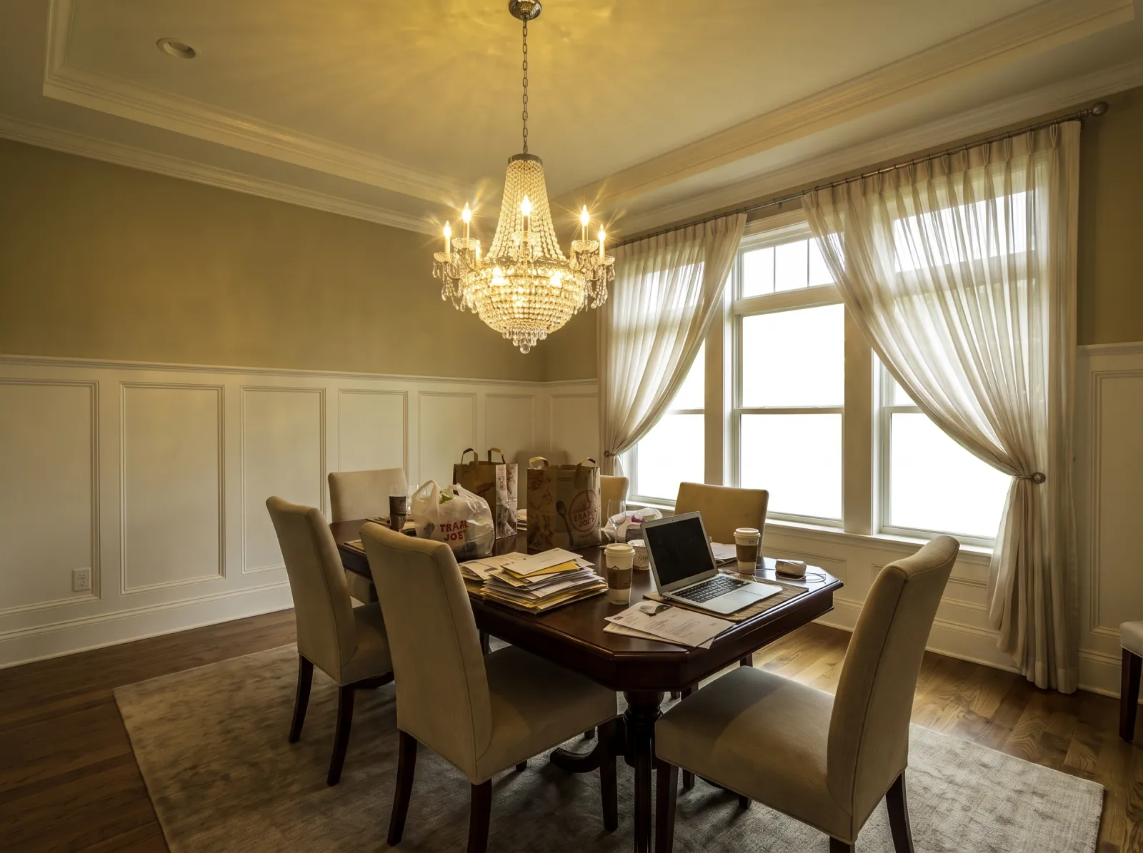 Dining room straight off the phone: blown window, chandelier glare, cluttered table